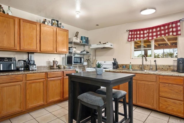 kitchen featuring range hood, stove, sink, light tile patterned floors, and light stone counters