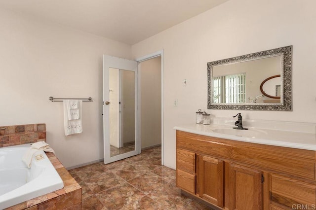 bathroom with vanity and a relaxing tiled tub