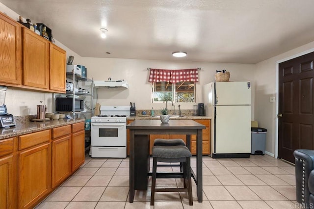 kitchen with light tile patterned floors, sink, and white appliances