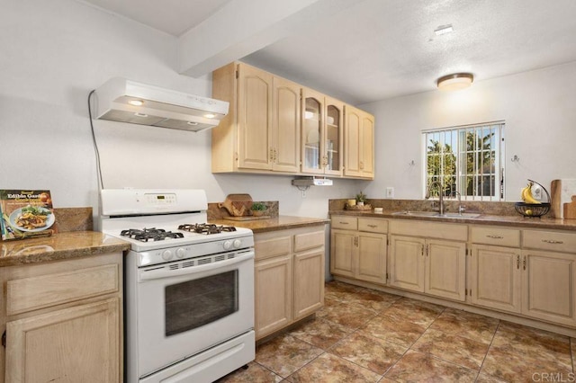 kitchen featuring range hood, gas range gas stove, sink, beamed ceiling, and light brown cabinets