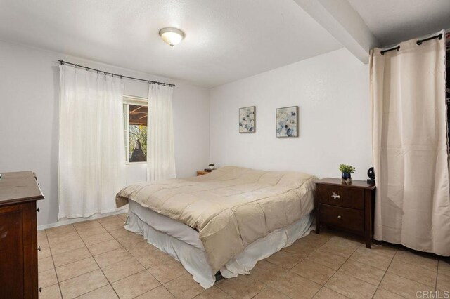 tiled bedroom with beamed ceiling