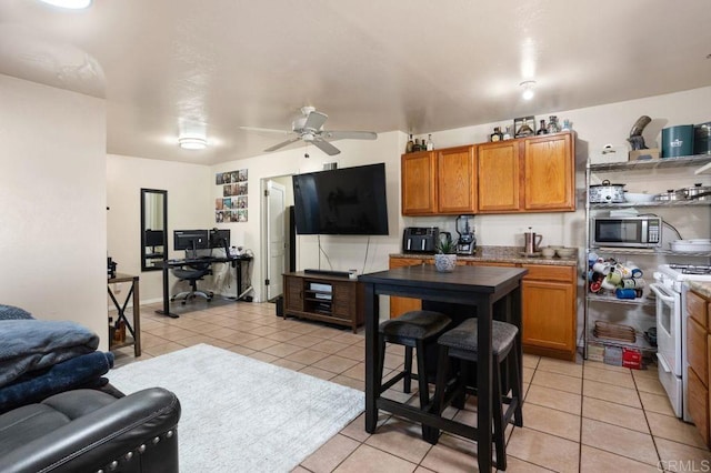 kitchen featuring ceiling fan, white range with electric stovetop, and light tile patterned floors