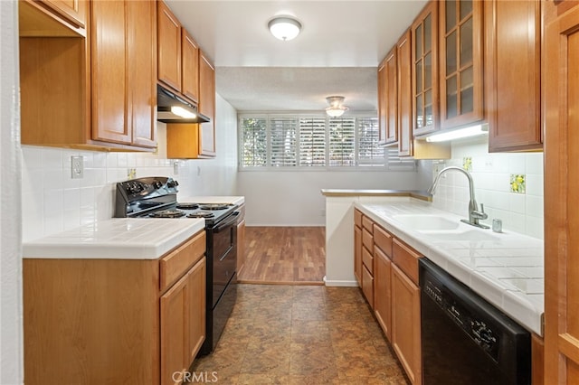 kitchen featuring tile counters, sink, tasteful backsplash, and black appliances