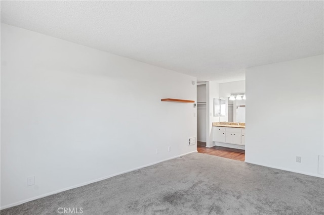 carpeted spare room with a textured ceiling