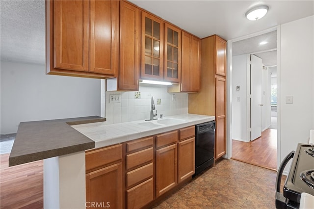 kitchen with tasteful backsplash, dishwasher, kitchen peninsula, sink, and range