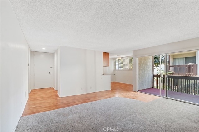 unfurnished room featuring a textured ceiling and light wood-type flooring