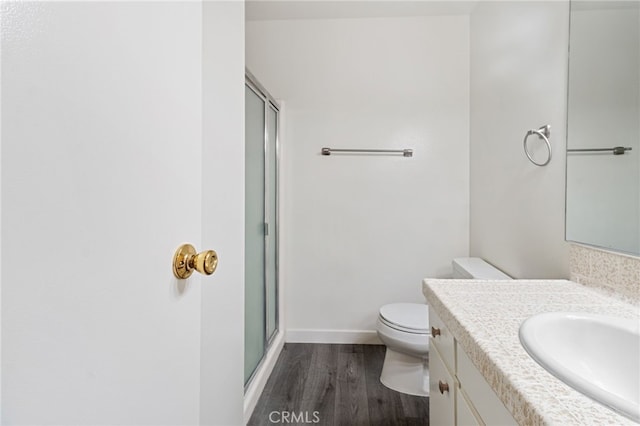 bathroom with a shower with door, hardwood / wood-style floors, toilet, and vanity