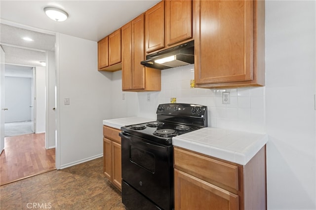 kitchen featuring decorative backsplash, tile counters, and black range with electric cooktop