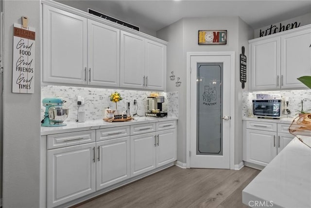 kitchen with decorative backsplash and white cabinets