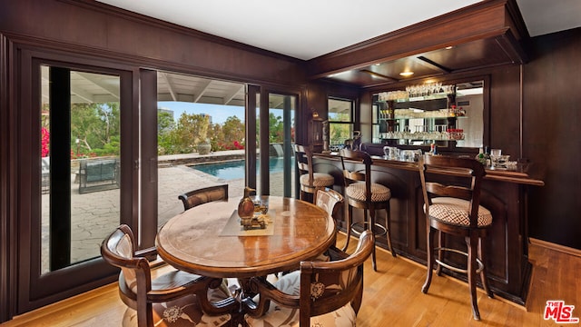 interior space featuring indoor bar, wood walls, and light hardwood / wood-style flooring