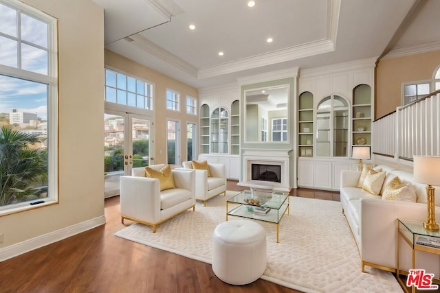 living room featuring french doors, hardwood / wood-style floors, plenty of natural light, and built in shelves