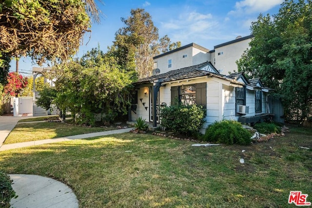 view of front of property featuring a front yard and cooling unit