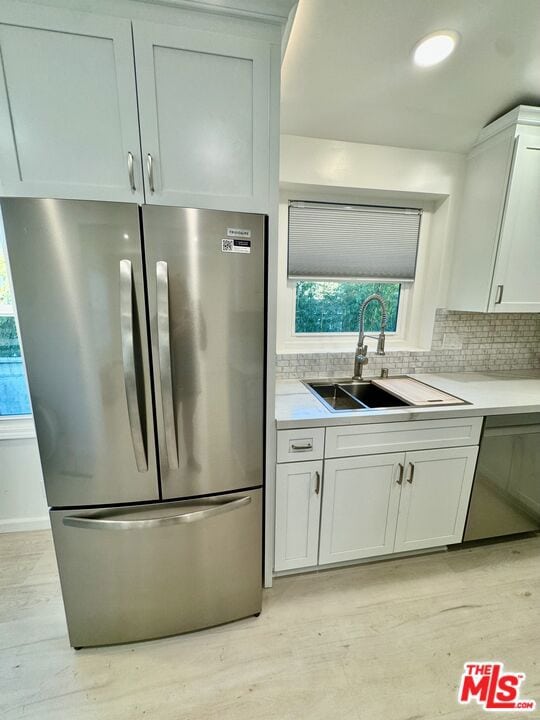 kitchen featuring stainless steel appliances, white cabinets, and sink