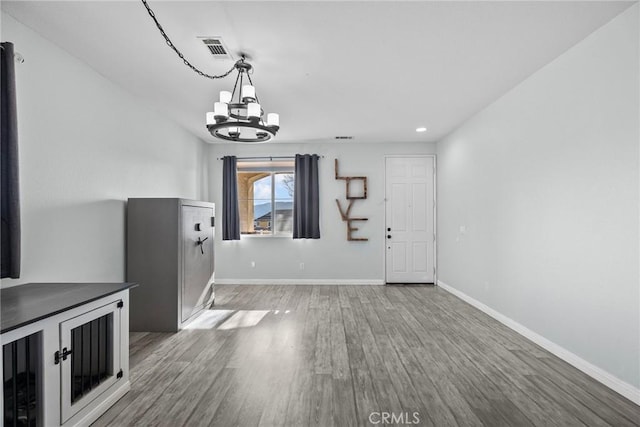 interior space with an inviting chandelier and hardwood / wood-style floors