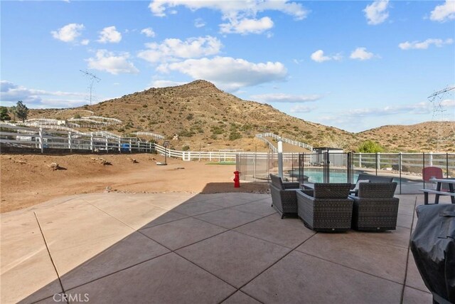 view of patio with a mountain view and a fenced in pool