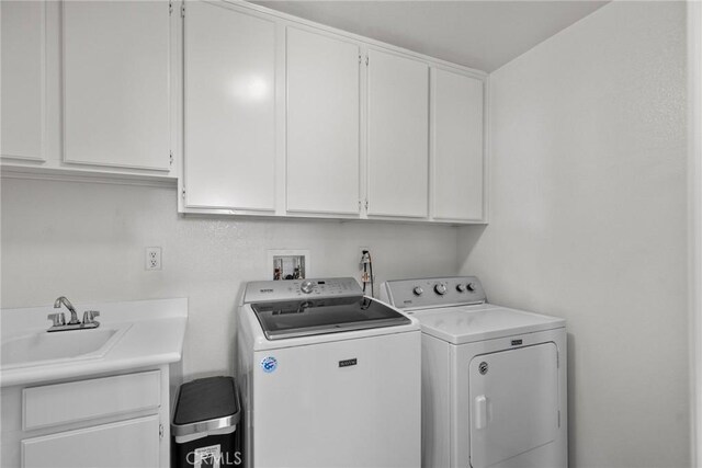 washroom with washing machine and dryer, sink, and cabinets