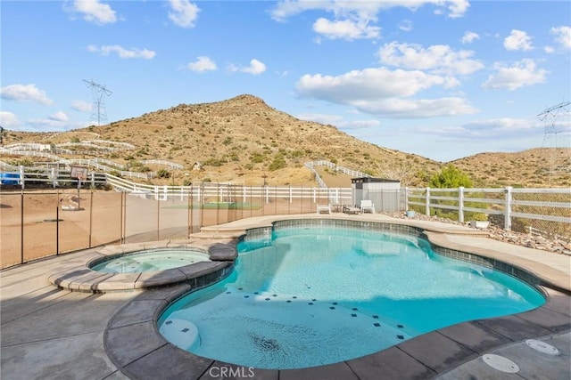 view of pool featuring a mountain view and an in ground hot tub