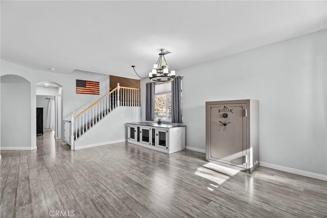 unfurnished living room with hardwood / wood-style floors and a notable chandelier