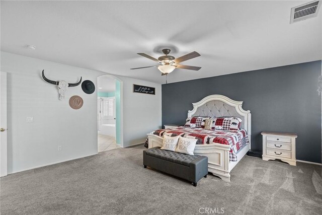 carpeted bedroom with ceiling fan and connected bathroom