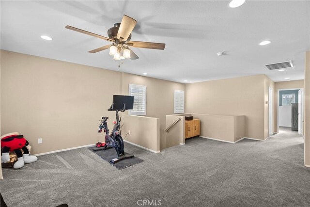 workout room with light carpet and ceiling fan