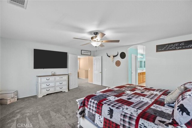 carpeted bedroom with ceiling fan and ensuite bathroom