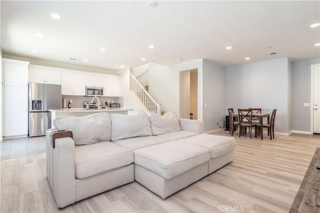 living room featuring light wood-type flooring and sink