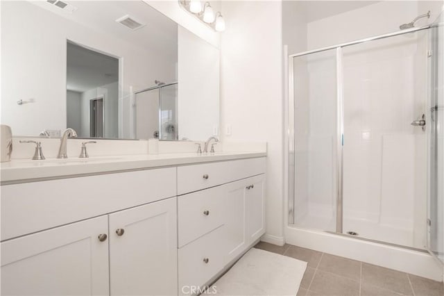 bathroom featuring walk in shower, vanity, and tile patterned flooring