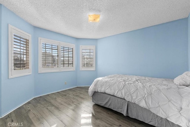 bedroom featuring a textured ceiling and wood-type flooring