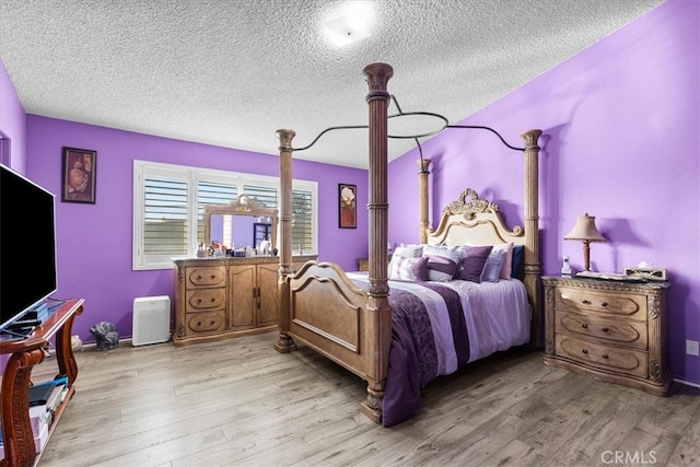 bedroom featuring light wood-type flooring and a textured ceiling