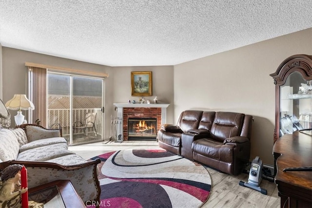 living room with a textured ceiling, light hardwood / wood-style flooring, and a fireplace