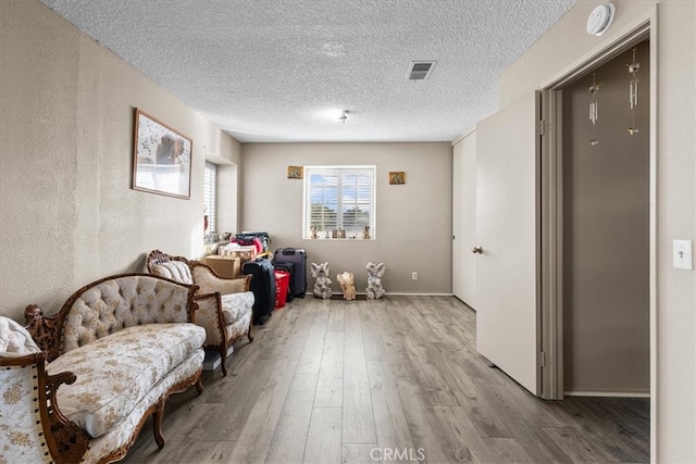 sitting room featuring a textured ceiling and light wood-type flooring