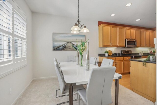 dining space with a notable chandelier and light carpet