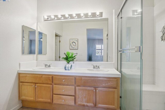 bathroom with walk in shower and vanity