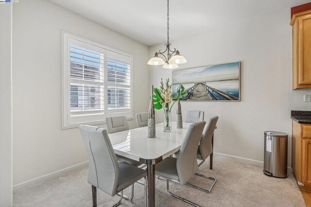 carpeted dining room featuring a chandelier