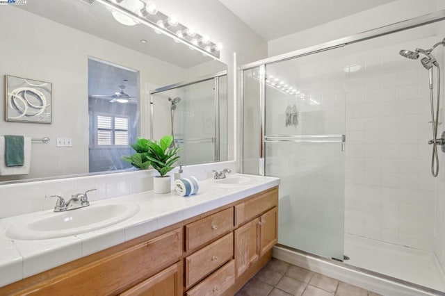 bathroom with ceiling fan, vanity, an enclosed shower, and tile patterned floors