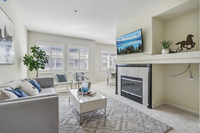 living room with carpet floors and a tiled fireplace