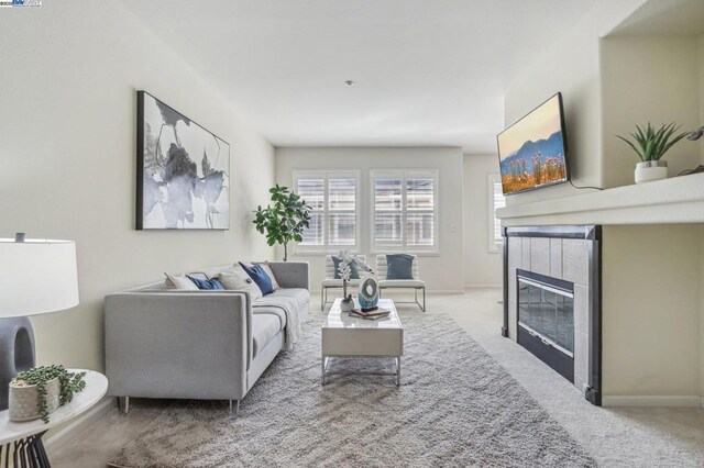 carpeted living room featuring a tile fireplace