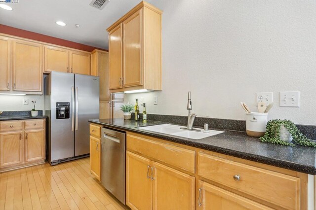 kitchen with sink, stainless steel appliances, light hardwood / wood-style floors, and light brown cabinets