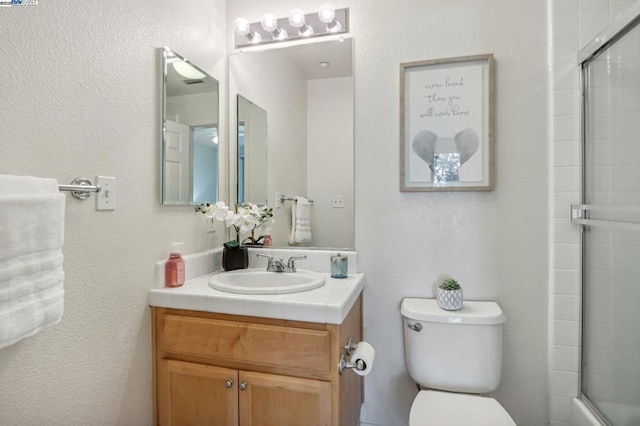 full bathroom featuring shower / bath combination with glass door, vanity, and toilet