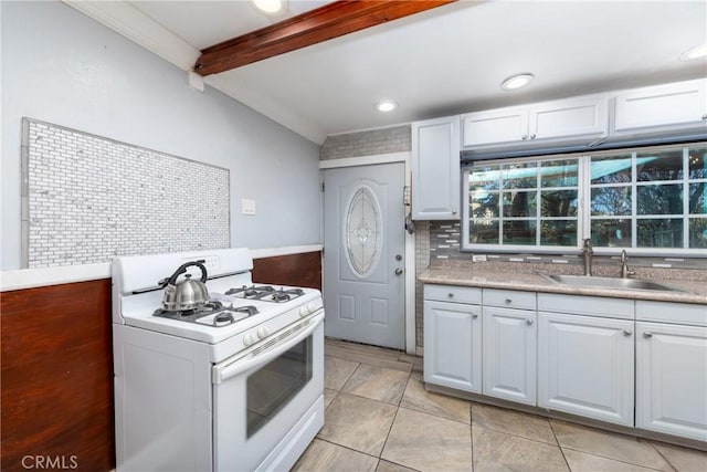 kitchen featuring white cabinetry, backsplash, sink, white gas stove, and lofted ceiling with beams