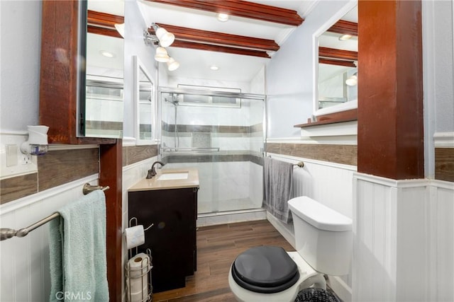 bathroom with hardwood / wood-style floors, an enclosed shower, vanity, toilet, and beam ceiling