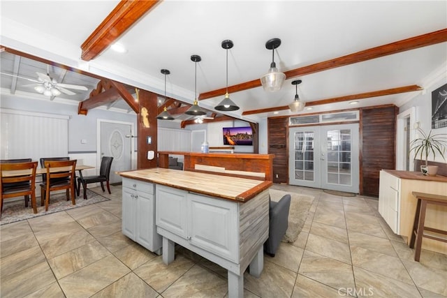 kitchen with white cabinets, butcher block counters, beamed ceiling, hanging light fixtures, and ceiling fan