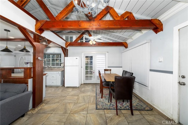 dining area featuring ceiling fan, vaulted ceiling with beams, and crown molding