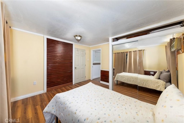 bedroom featuring a closet, ornamental molding, and hardwood / wood-style flooring