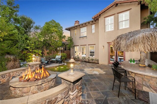 patio terrace at dusk with a bar and a fire pit