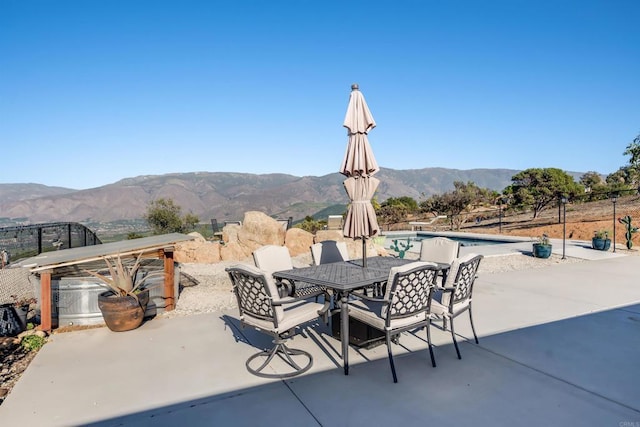 view of patio with a fenced in pool and a mountain view