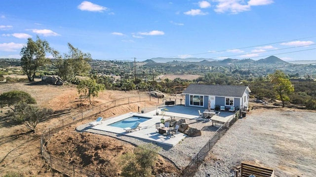 view of swimming pool with an outdoor hangout area, a patio area, a mountain view, and an outdoor structure