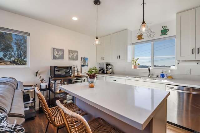 kitchen featuring dishwasher, a center island, pendant lighting, sink, and white cabinetry