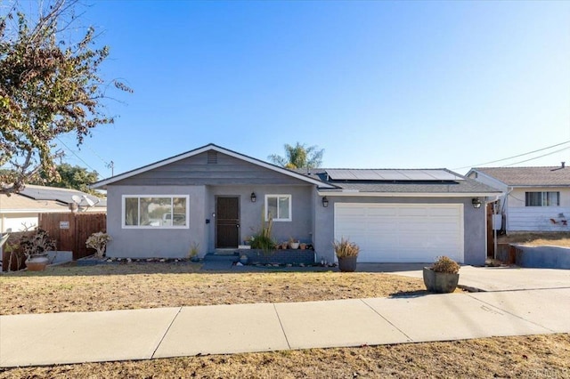 single story home featuring a garage and solar panels