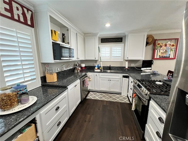 kitchen with dark wood-type flooring, white cabinetry, stainless steel appliances, and dark stone counters